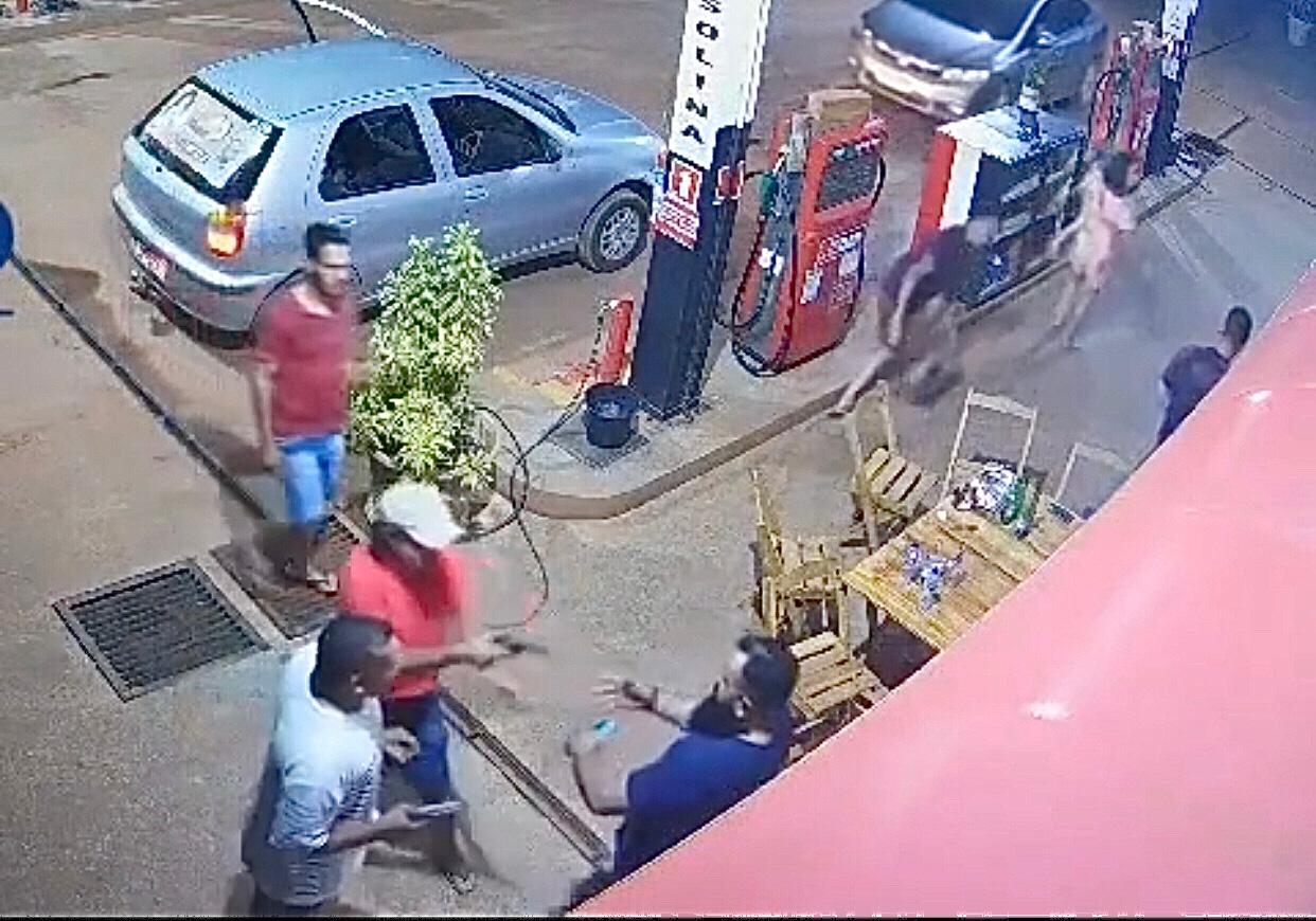 Imagem de criminosos exucatando homem em posto de gasolina